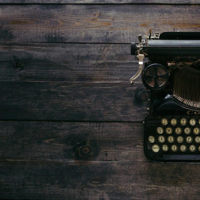 black Corona typewriter on brown wood planks