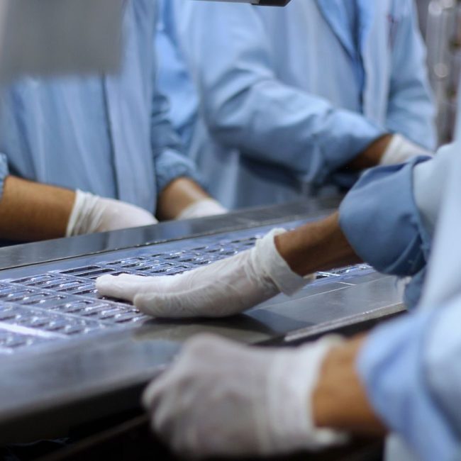 Workers in a pharmaceutical facility packaging tablets in Islamabad.