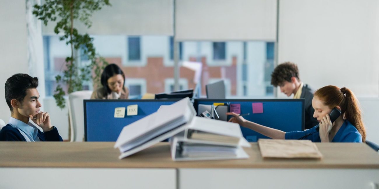 Contemporary office setting with diverse employees working diligently at their cubicles.