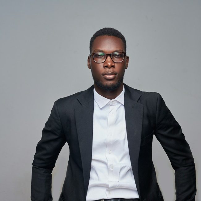 a man in a suit and glasses posing for a picture