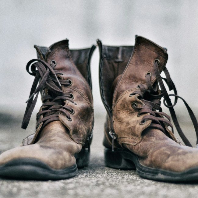 pair of brown leather boots in pavement