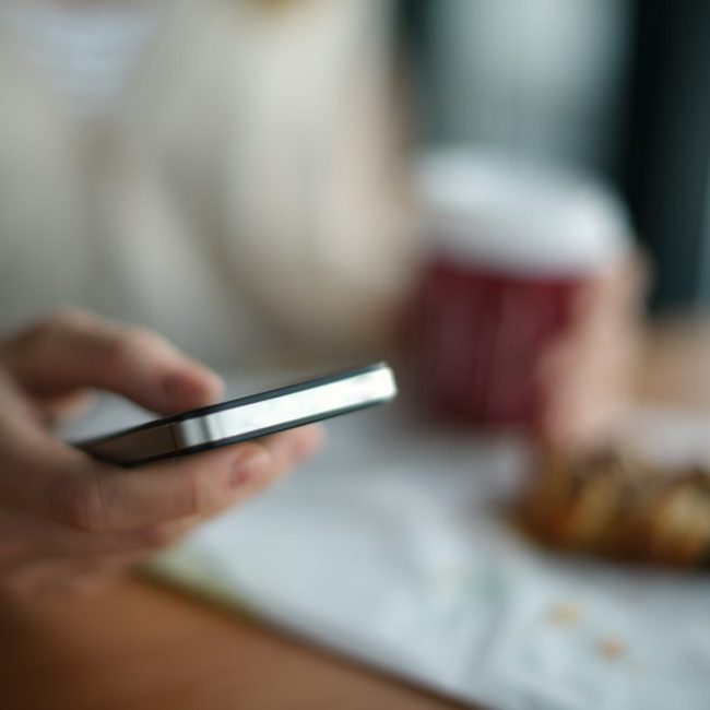 selective focus photography of person holding gray phone
